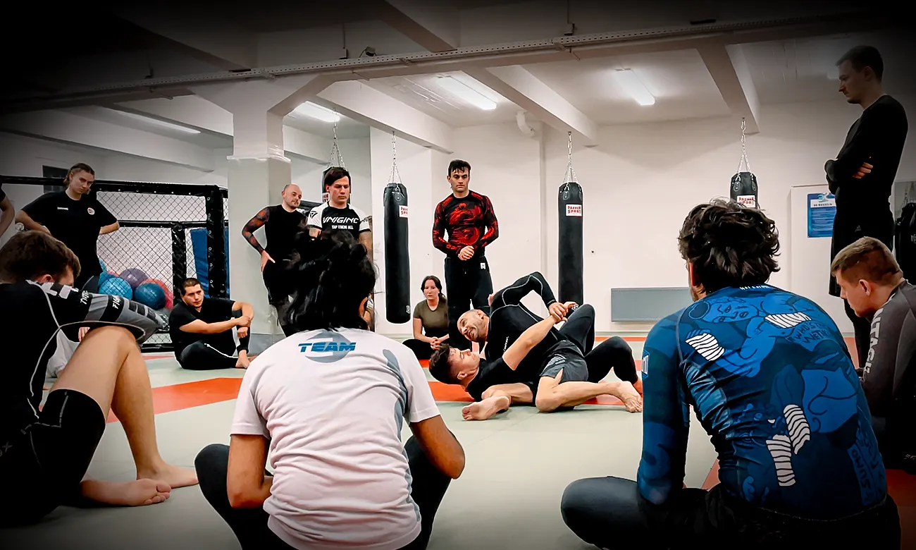 Der Head Coach zeigt eine Übung beim BJJ Unterricht auf der Trainingsfläche von Combat Club Cologne Gym
