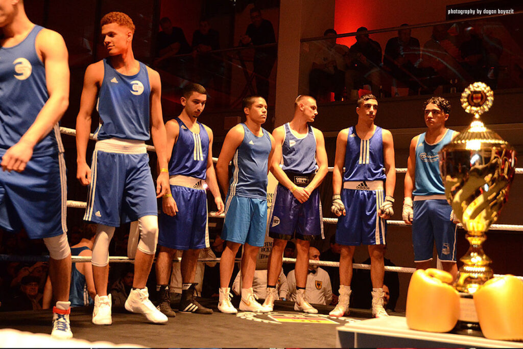 mehrere Boxer in blauer Uniform stehen im Ring bei Golden Gloves in Münster