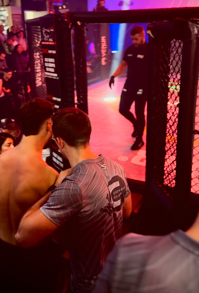 K1 GMC Olympix – ein Coach und K1 Fighter von Combat Club Cologne stehen vor MMA-Cage vor dem K1 Wettkampf