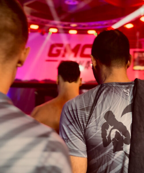 K1 GMC Olympix – zwei Coaches und der K1 Fighter von Combat Club Cologne laufen gemeinsam zum MMA-Cage vor dem K1 Wettkampf