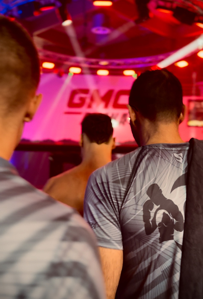 K1 GMC Olympix – zwei Coaches und der K1 Fighter von Combat Club Cologne laufen gemeinsam zum MMA-Cage vor dem K1 Wettkampf